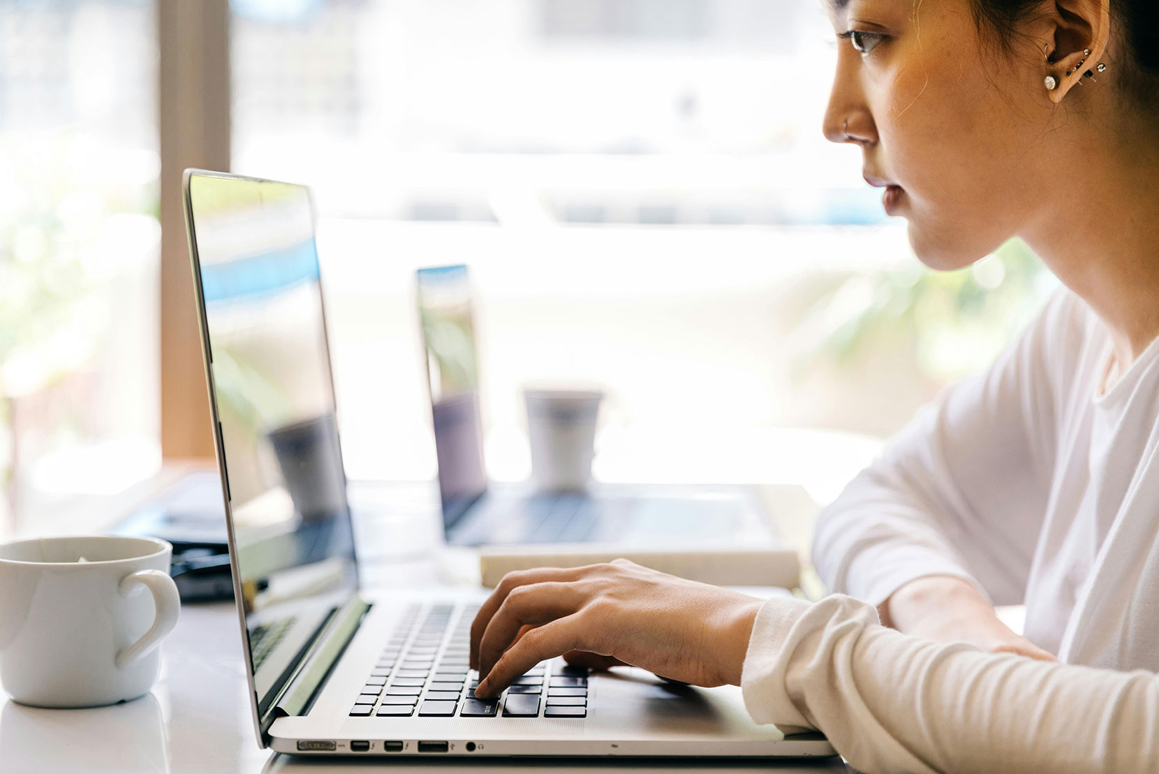 Asian woman typing on laptop computer